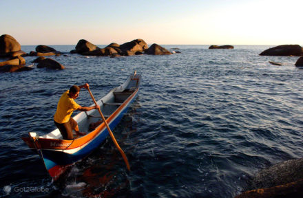 Pescador manobra barco junto à Praia de Bonete, Ilhabela, Brasil