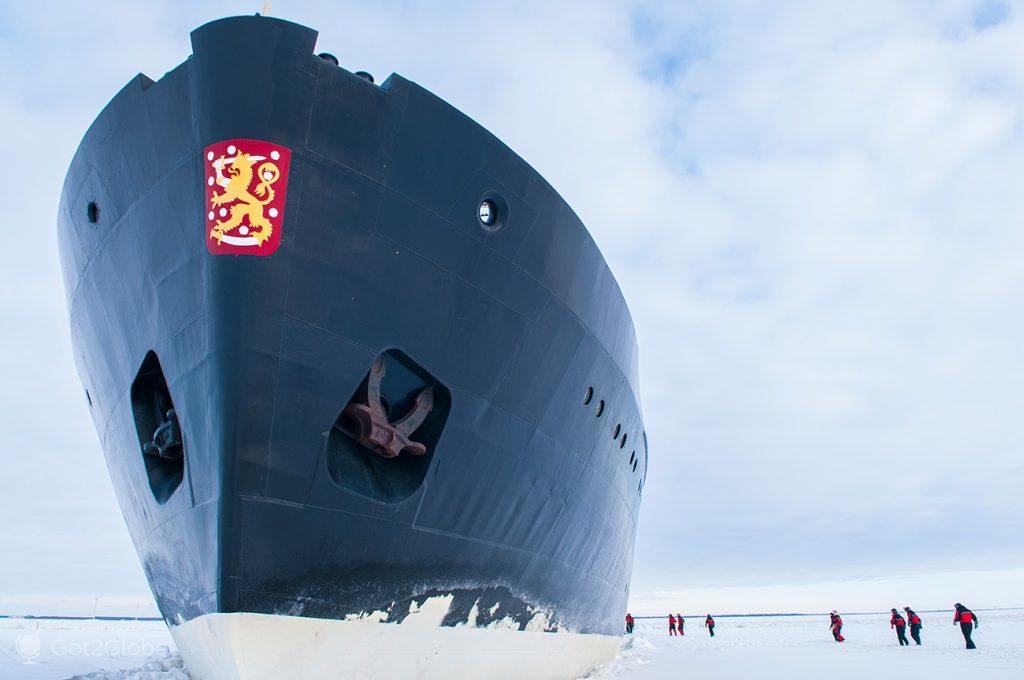 Passagiere auf der eisigen Oberfläche des Bottnischen Meerbusens am Fuß des Eisbrechers „Sampo“, Finnland