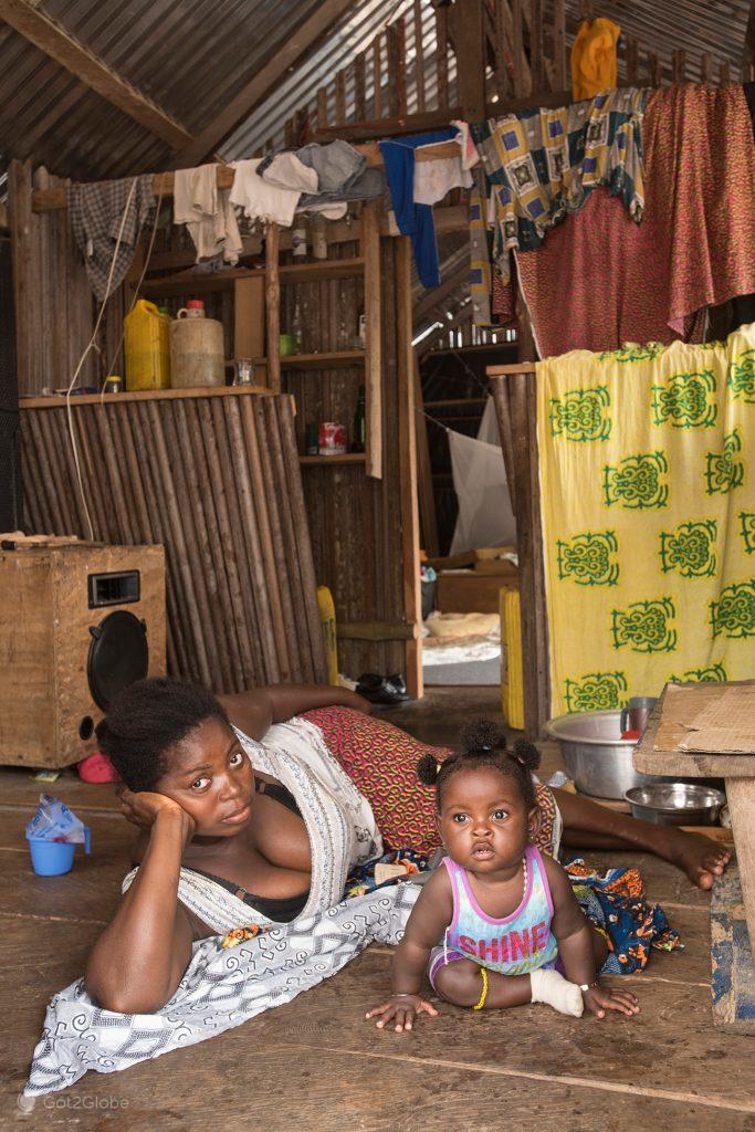 Mother and daughter rest on their stilt house in Nzulezu, Ghana