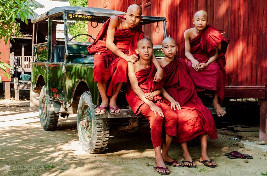 Jovens monges budistas sobre um jipe de um mosteiro de Mandalay