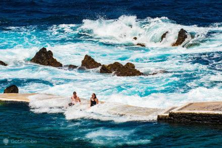 Banhistas sobre o limiar entre as Piscinas Naturais e o oceano Atlântico, Porto Moniz