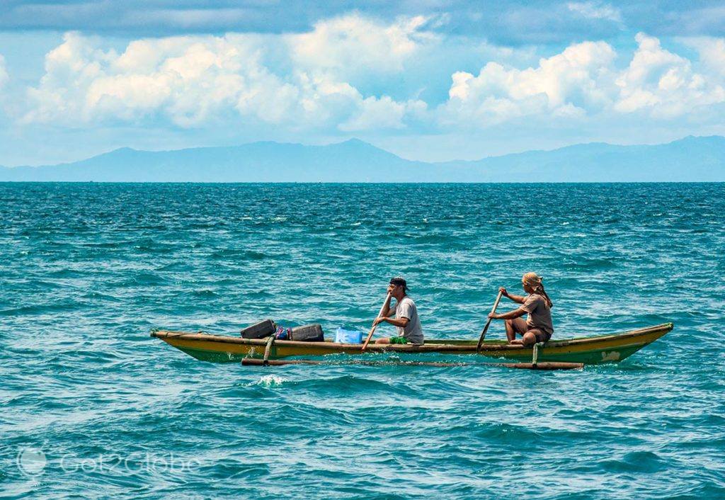 Remadores a bordo de uma pequena bangka