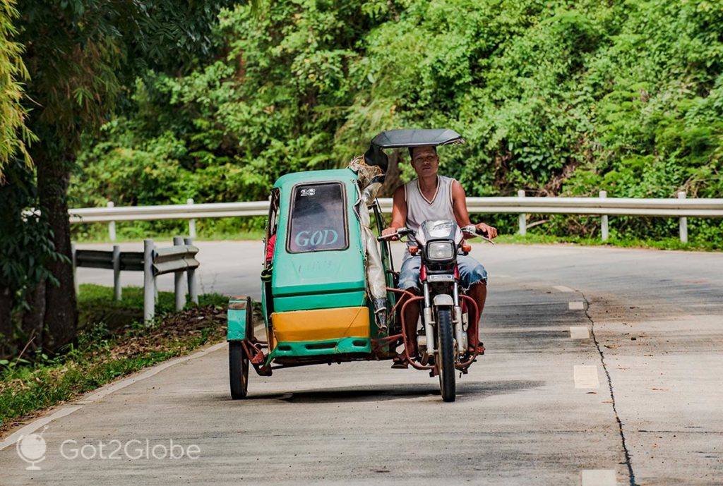 Condutor e passageiros de um tricycle, numa estrada da ilha de Guimaras