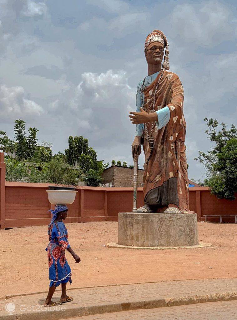 Moradora passa junto à estátua do rei Toffa I
